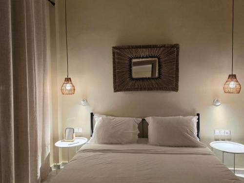 a bedroom with a bed with two tables and two lights at Rastoni Suites Xylokastro 1 in Melission