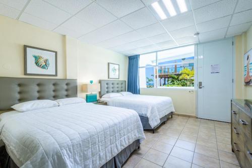 リンコンにあるVilla Cofresiのベッドが2つと窓があるホテルの部屋