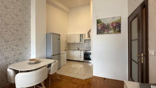 Una pequeña cocina con una mesa y un refrigerador. en Apartment City kvart, en Podgorica