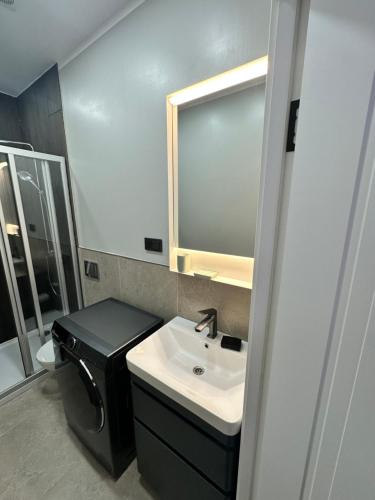 a bathroom with a sink and a mirror at Lauvas Rezidences - Self check-in in Rīga