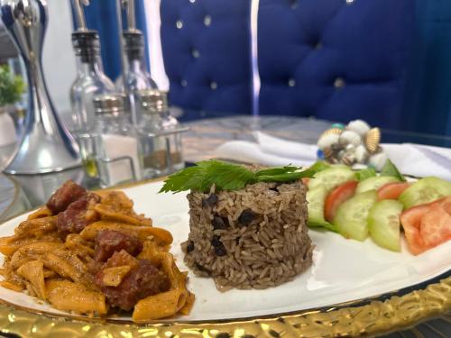 a plate of food with rice and fruit on a table at Casa De Las Muñecas RH in Santo Domingo