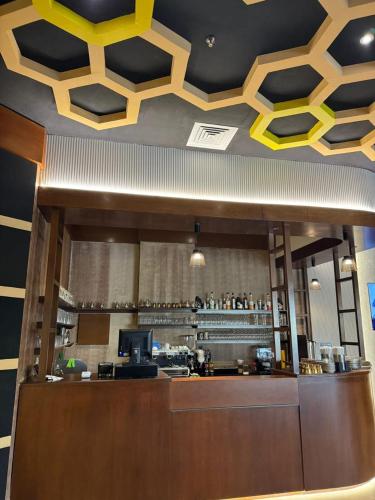 a restaurant with a bar with yellow and black ceilings at Acacia Hotel by BP Management in Ras al Khaimah