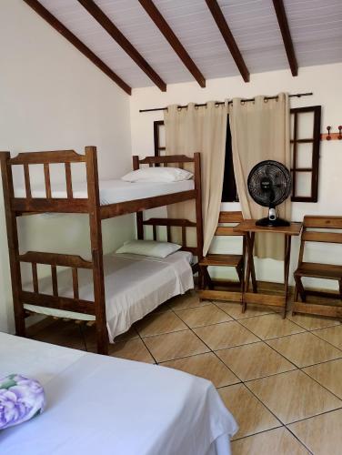 a room with two bunk beds and a fan at Pousada João e Maria in Trindade