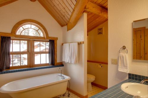 a bathroom with a tub and a toilet and a sink at Rustic Gotham Bay Cabin on Lake Coeur dAlene in Harrison