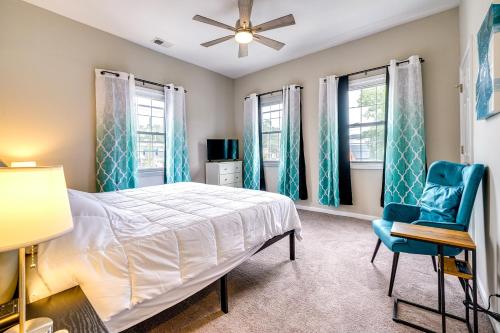 Un dormitorio con una cama y una silla azul. en Wilmington Getaway Near Riverwalk and Downtown!, en Wilmington