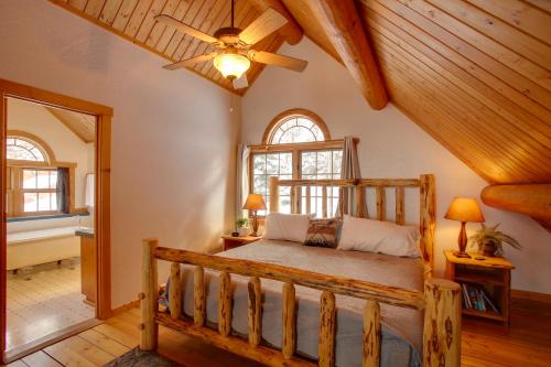 a bedroom with a wooden bed and a ceiling fan at Rustic Gotham Bay Cabin on Lake Coeur dAlene in Harrison