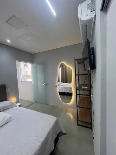 a bedroom with a bed and a mirror on the wall at Recanto do Sol in Governador Celso Ramos
