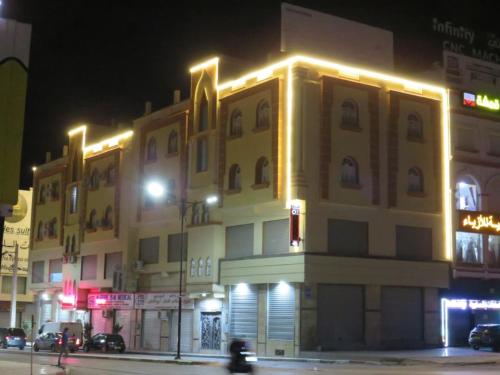 a large yellow building with lights on it at night at OZ motel in Mechta el Hadj Douibi