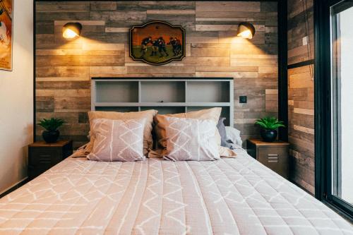 a bedroom with a bed and a wooden wall at La toulousaine in Sablons