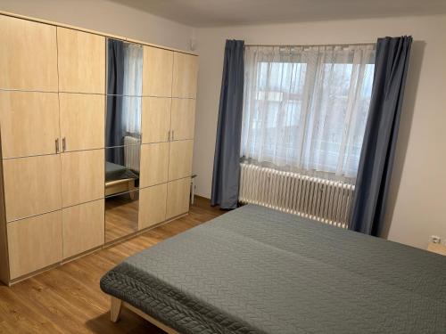 une chambre avec un lit et une grande fenêtre dans l'établissement Prázdninový dům, à Kout na Šumavě