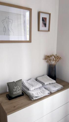 a shelf with three towels and a vase on it at HOUSE RODRIGUEZ in San Lazzaro di Savena