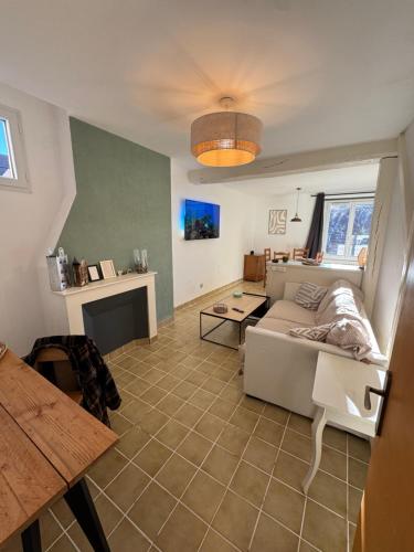 a living room with a couch and a table at L'Appart du Coq - Proche du Zoo de Beauval & des châteaux in Selles-sur-Cher