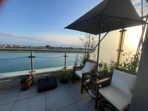 a balcony with two chairs and an umbrella at Special Occasion, Stunning sea view balconied Penthouse suite in Shoreham-by-Sea