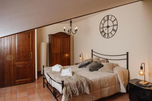 a bedroom with a bed and a clock on the wall at Arcinazzohouse in Canterano