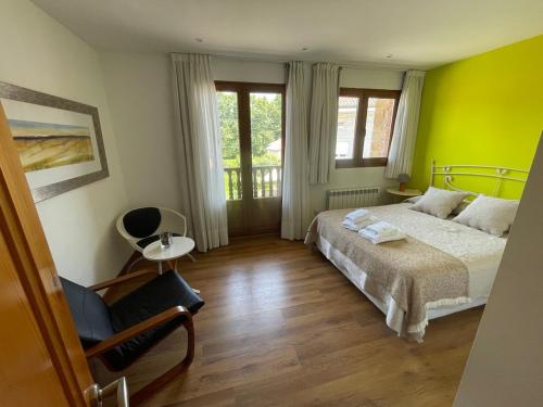 a bedroom with a bed and a chair in it at Casa pareada rural Elechino in Entrambasaguas
