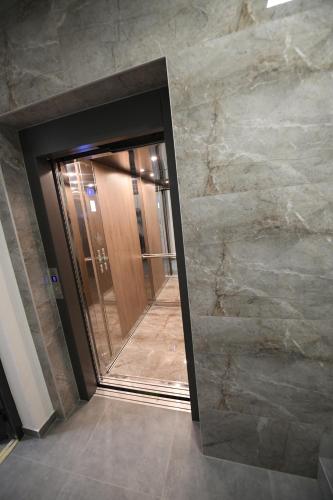 a bathroom with a mirror and a walk in shower at Cristal Palace Suites 003 in Kragujevac