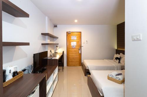 バンコクにあるBed By City Hotelのベッド2台とテレビがあるホテルの部屋