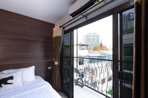 バンコクにあるBed By City Hotelのベッドとバルコニーのある寝室