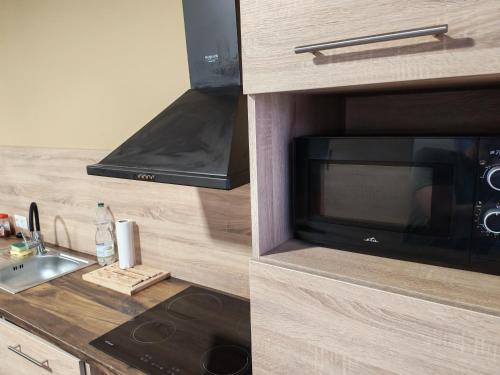 a kitchen with a sink and a microwave at Zo. Low Budget House in Bakonykoppány
