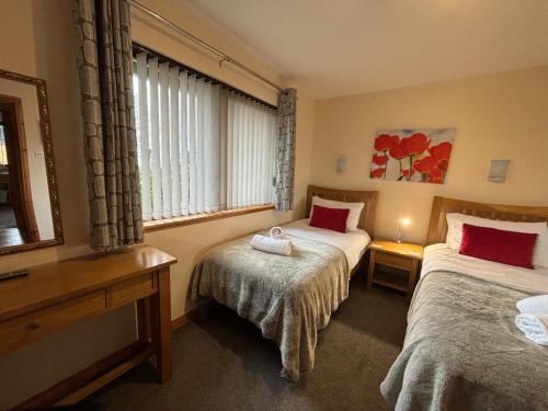 a hotel room with two beds and a window at No 1 High Park Lodges in Orkney