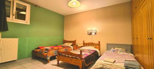 two beds in a room with green walls at Kounis Villa in Chalkida