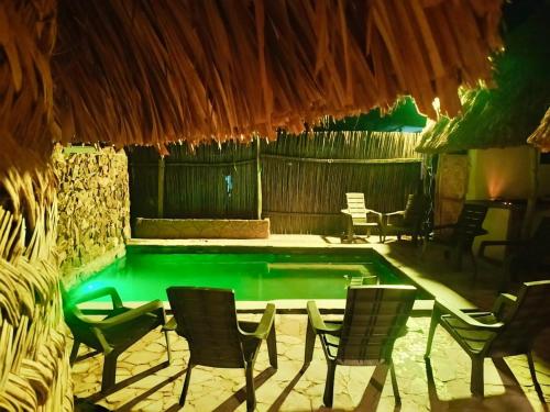 una piscina con sillas y una mesa y una piscina en Kogui Aldea, en Palomino