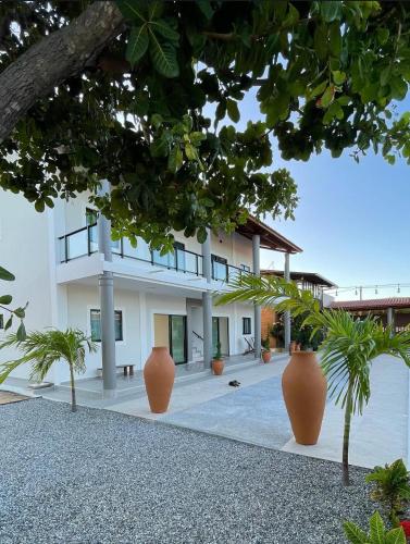 a building with orange vases in front of it at Da terra Altos in Aracati