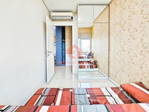 uma sala de estar com uma cama num quarto em Strategic 3BR Thamrin Residence em Jacarta