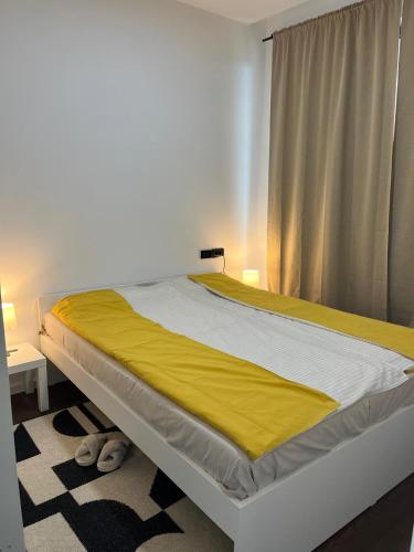 a bedroom with a large bed with a yellow blanket at Cozy apartment Kosmaj Residence in Rogača
