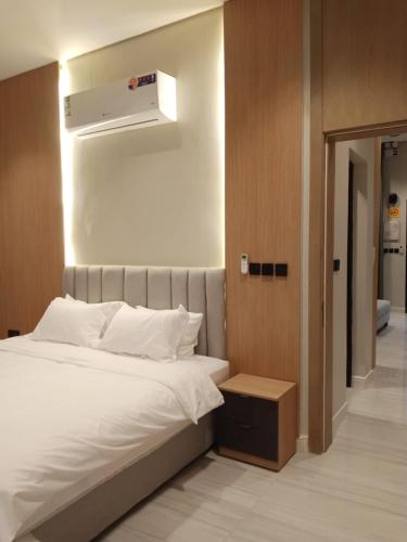 a bedroom with a white bed and a air vent at شاليهات أجواء الريف in Dammam