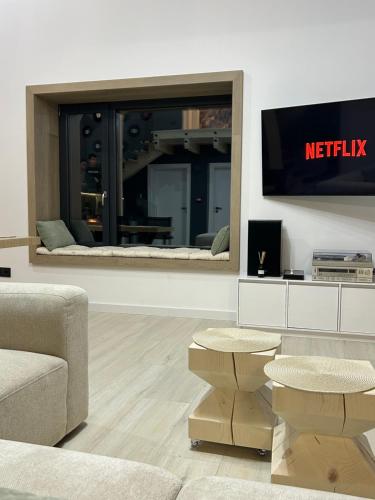 a living room with a television on a wall at Sol Chalet Maramures in Borşa