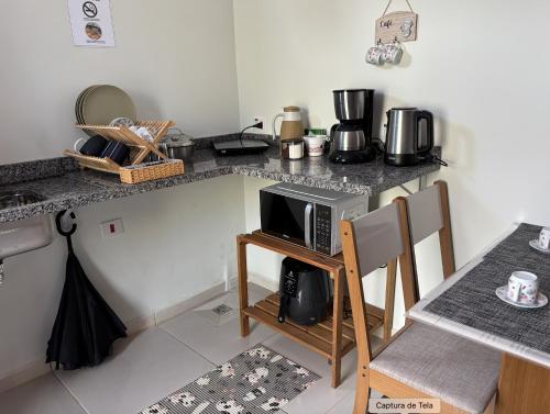 una cucina con un piano di lavoro con un forno a microonde di Rancho do Viajante Flat APARTAMENTO A a Castro