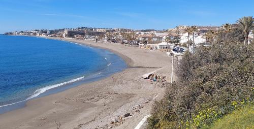 Una playa con gente en la arena y el océano. en Olas del Sur Apartment, en La Cala de Mijas
