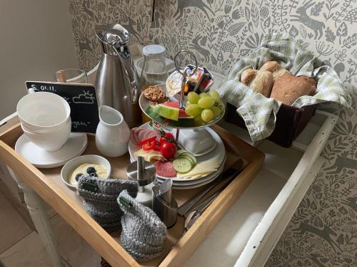 uma bandeja de comida sobre uma mesa com pão e frutas em Pension Domquartier Naumburg em Naumburg