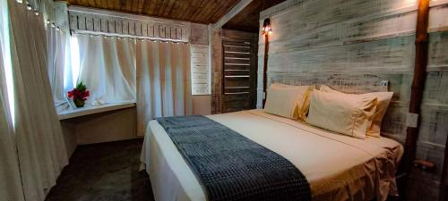 a bedroom with a bed with a wooden wall at Casa Janjão in Icaraí