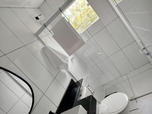 een badkamer met een toilet en een raam bij Apartamento bem localizado São Sebastião - SP in São Sebastião