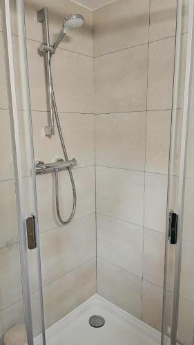 a shower with a glass door with a shower head at Het Hertenbos Chalet 136 - Bos- Groene Oase- Rustmoment- Zwembad in Durbuy