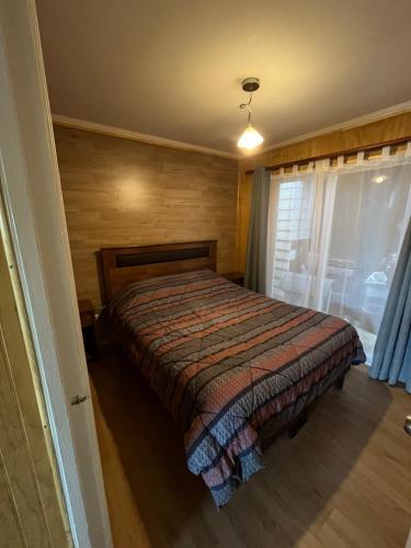 a bedroom with a bed in a room with a window at Casa Amayita in Puerto Varas