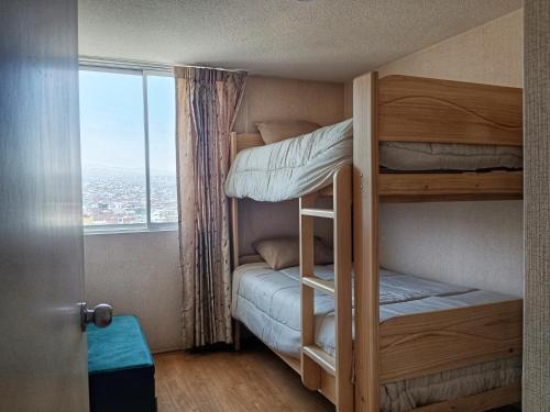 a small room with bunk beds with a window at Hampiwasi in Miraflores