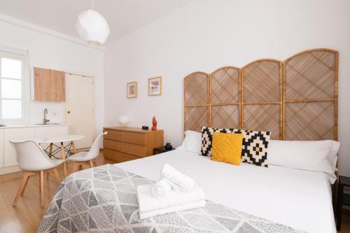 Un dormitorio con una cama grande con cabecero de madera. en Estudio Centro de Sevilla, en Sevilla