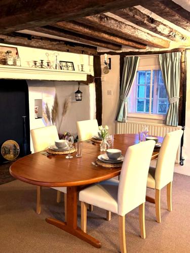a dining room table with white chairs around it at 4 Bed Cottage with Hot Tub near Wyboston Lakes in Wyboston