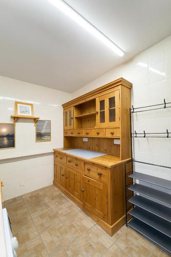 a large kitchen with wooden cabinets and a staircase at 4 Bed Cottage with Hot Tub near Wyboston Lakes in Wyboston