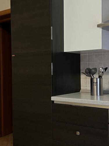 a kitchen with black and white cabinets and a counter at Residence Cà Mazzini in San Giorgio Di Mantova