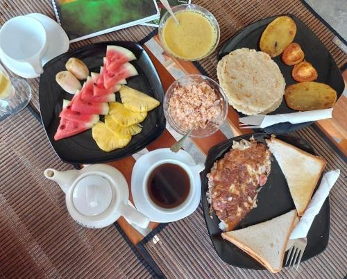 a table with two plates of food and a cup of coffee at Cabana Unawatuna in Unawatuna