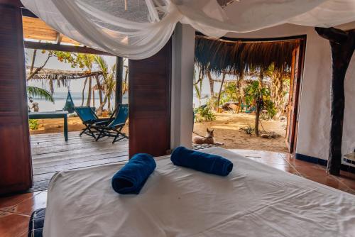 Un dormitorio con una cama con almohadas azules. en Bambú Ecocabañas, en San Agustinillo