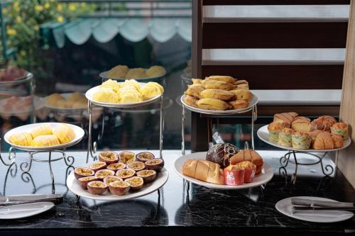 a bunch of different types of pastries on plates on a table at Tam Coc Lion Kings Hotel & Resort Ninh Binh in Ninh Binh