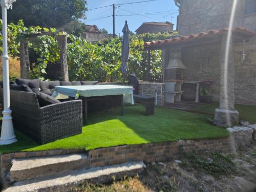 a backyard with a table and a fireplace at Casinha da Lu in Arcos de Valdevez