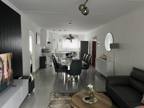 a living room and kitchen with a table and chairs at 2 Bedroom Condo in Sunninghill Sandton in Sandton
