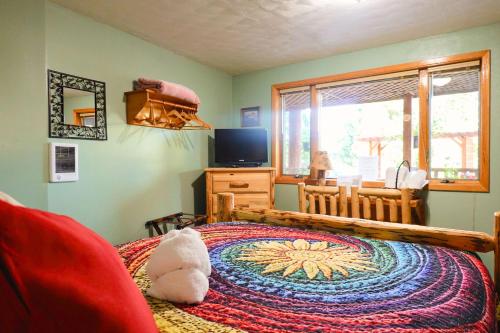 a bedroom with a bed and a television and a window at Timber Wolf Resort in Hungry Horse