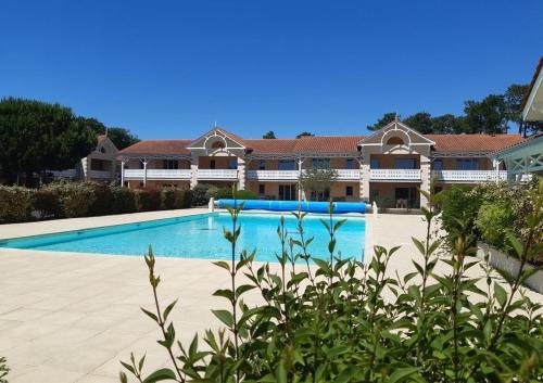 a swimming pool in front of a house at Superbe T4 à 1,9km des plages in Soulac-sur-Mer